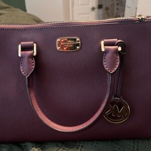 Micheal Kor Maroon tote bag with cross body strap.